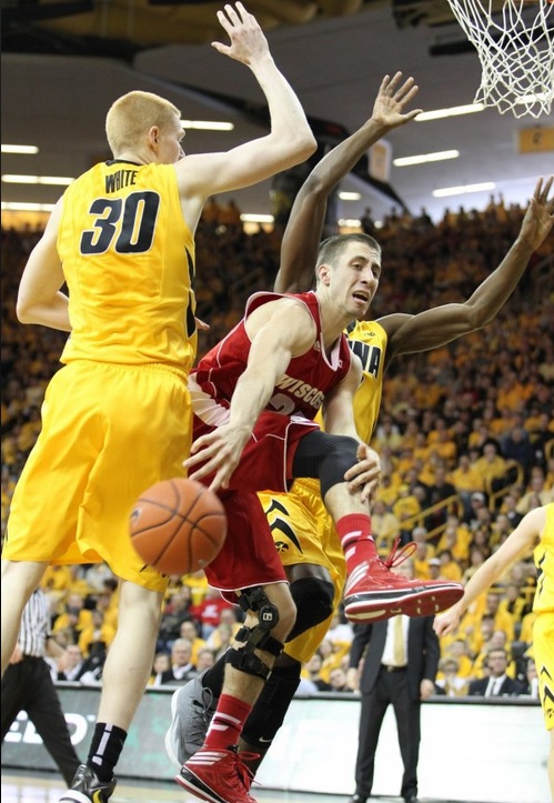 Badgers guard Josh Gasser (21) gets caught under the basket between Iowa’s Aaron White (30) and Gabriel Olaseni (0). - Reese Strickland, USA TODAY