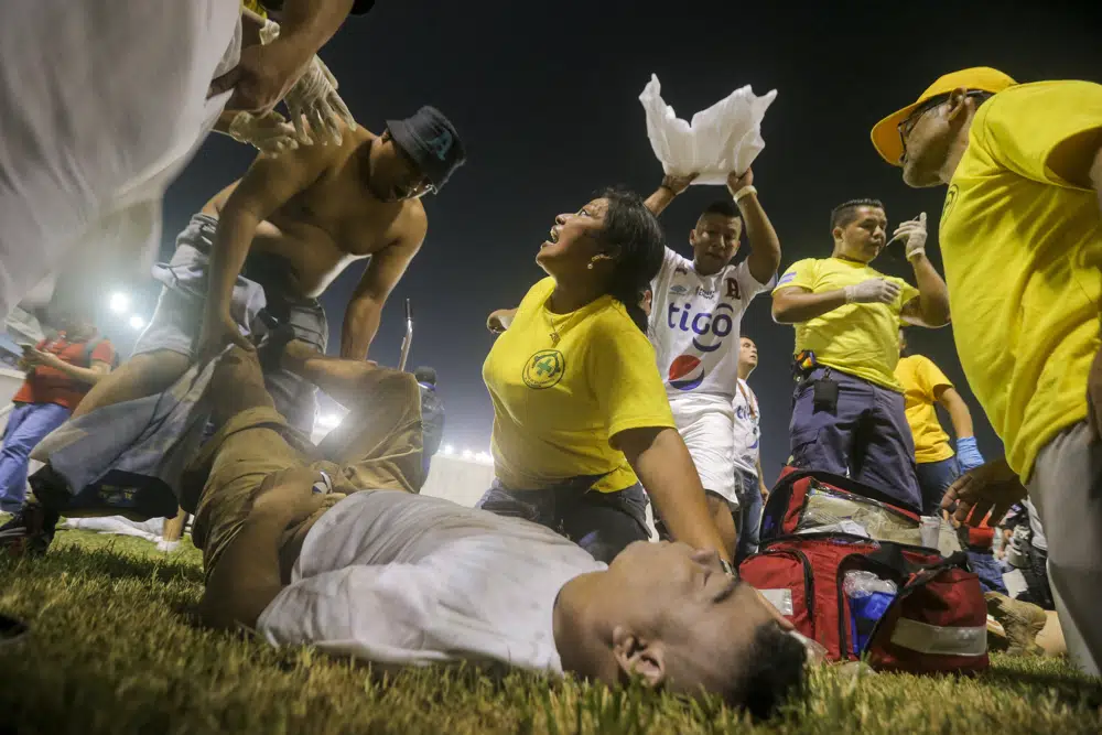 Angry fans stampede through gate at El Salvador soccer match killing 12, injuring dozens