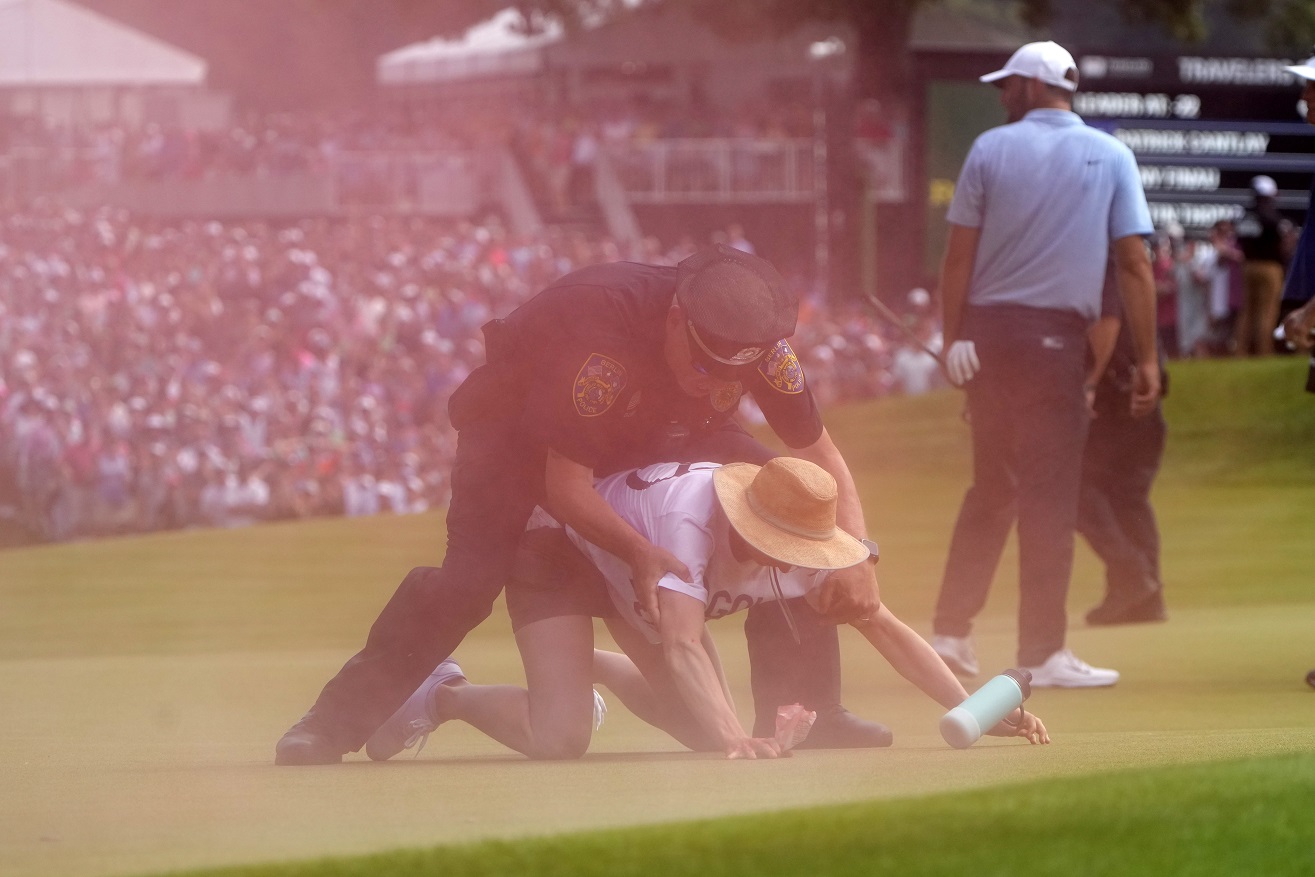 Six climate protesters run onto 18th green, spraying powder and delaying finish of PGA Tour event